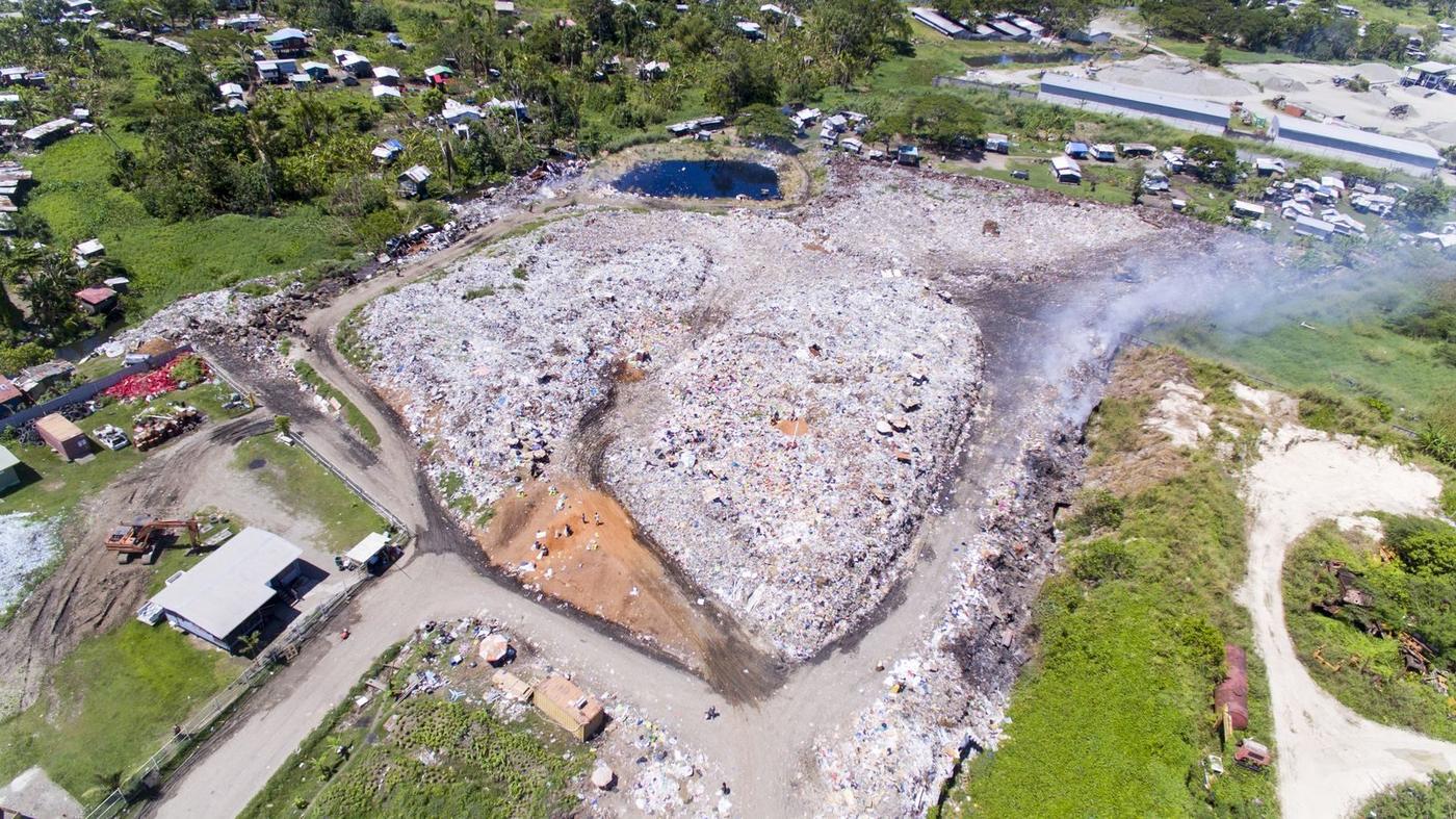 Aerial view of a large open dumpsite beside the sea