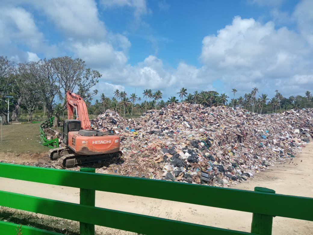 Excavator working on a large island dumpsite